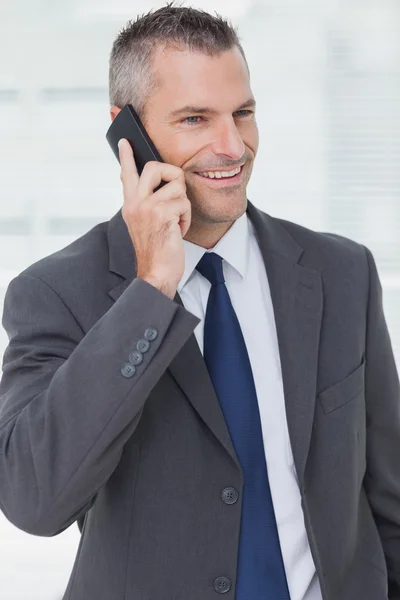 Empresário atencioso posando enquanto tem um telefonema — Fotografia de Stock