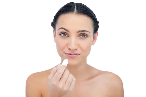 Curious natural model using lip balm — Stock Photo, Image