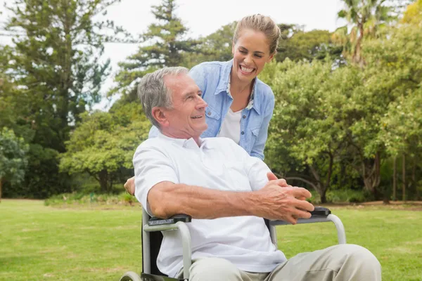 Lachender Mann im Rollstuhl und Tochter im Gespräch — Stockfoto