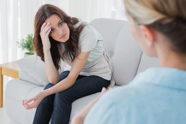 Besorgte Frau sitzt und schaut ihren Therapeuten an — Stockfoto