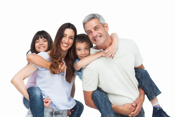 Smiling parents holding their children on backs — Stock Photo, Image
