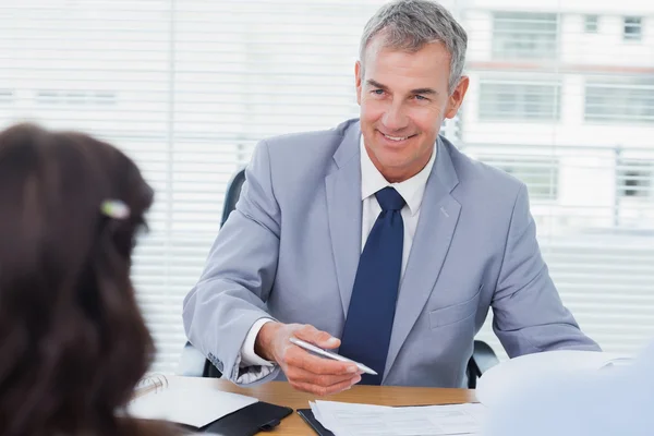 Sorrindo agente imobiliário completando contrato com casal — Fotografia de Stock