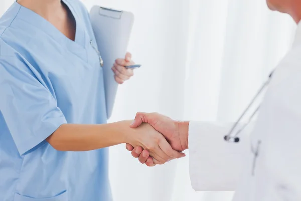 Close up on surgeon and doctor shaking hands — Stock Photo, Image