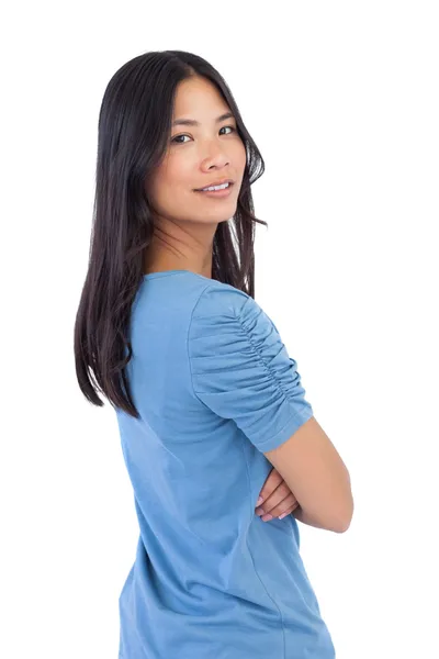 Sonriendo mujer asiática con los brazos cruzados mirando por encima de su hombro — Foto de Stock