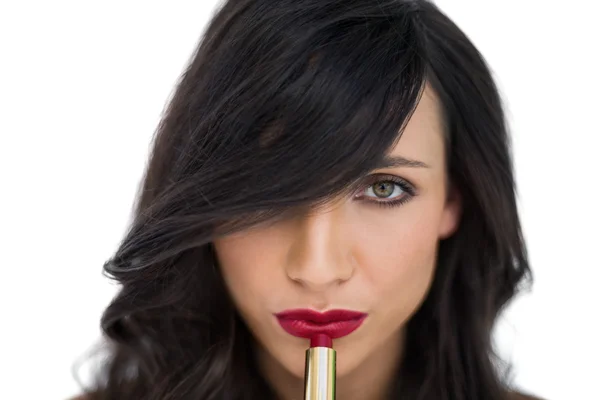 Sensual brunette applying red lipstick — Stock Photo, Image