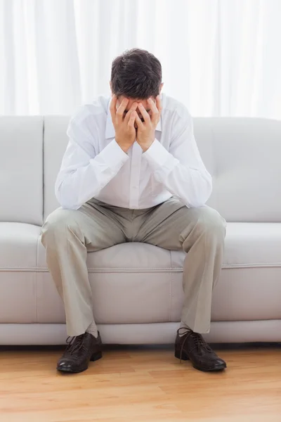 Depressed young man sitting on sofa — Stock Photo, Image