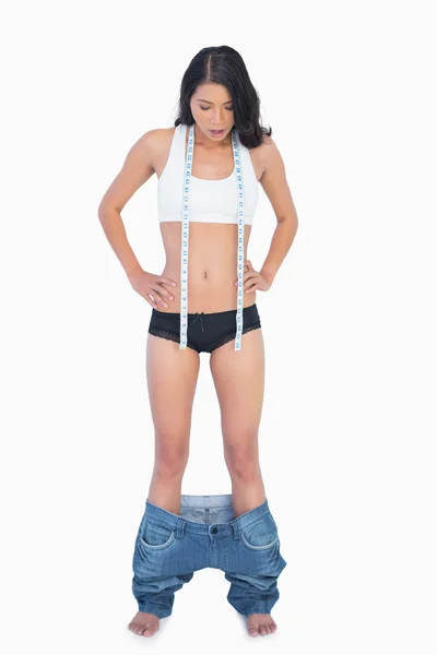Женские джинсы падают, потому что она похудела. — стоковое фото