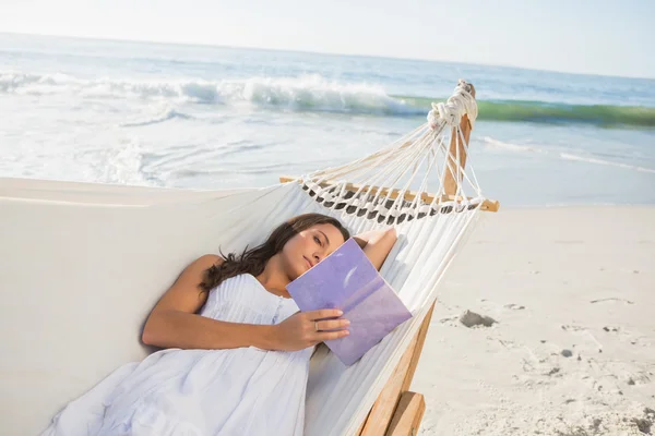 Frau liegt auf Hängematte und liest Buch — Stockfoto