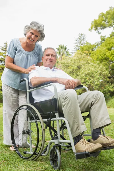 Улыбающийся взрослый мужчина в инвалидной коляске с партнером — стоковое фото
