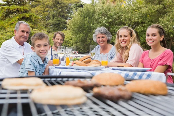 Счастливая семья устраивает барбекю в парке вместе — стоковое фото