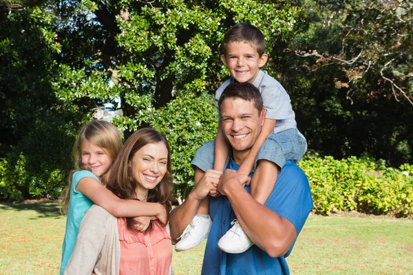Happy family with children on their shoulders — Stock Photo, Image