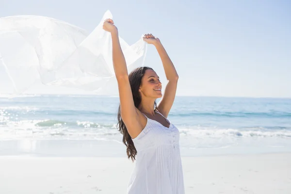 Krásná brunetka v bílých slunce šaty hospodářství sarong — Stock fotografie