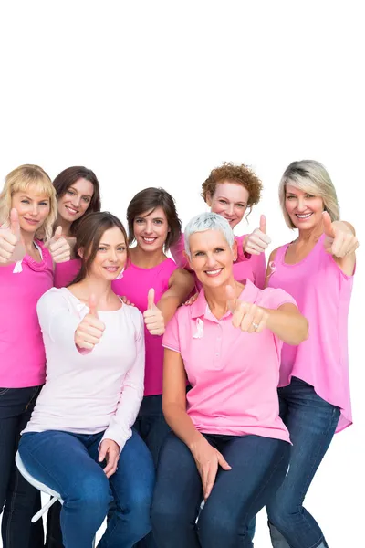 Positive hübsche Frauen posieren und tragen rosa für Brustkrebs — Stockfoto