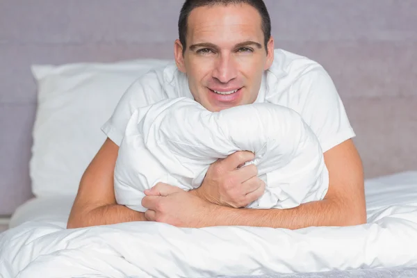 Hombre feliz abrazando su almohada — Foto de Stock