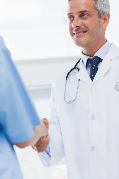Happy doctor does handshake with a nurse — Stock Photo, Image