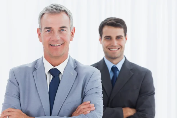 Hombres de negocios sonrientes posando mirando a la cámara — Foto de Stock