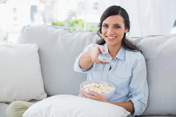 Vacker kvinna tittar på tv med popcorn — Stockfoto