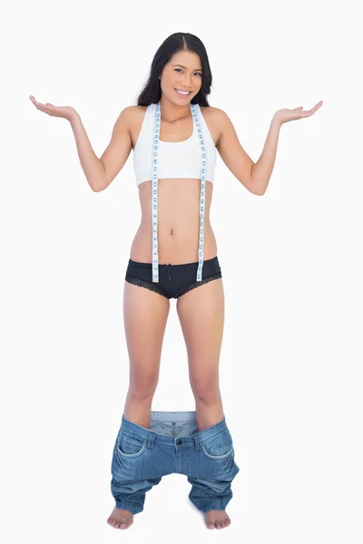 Lächelnde Frau in Jeans fällt um, weil sie Gewicht verloren hat — Stockfoto