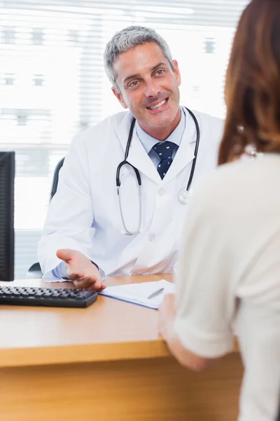Счастливый доктор разговаривает со своим пациентом — стоковое фото