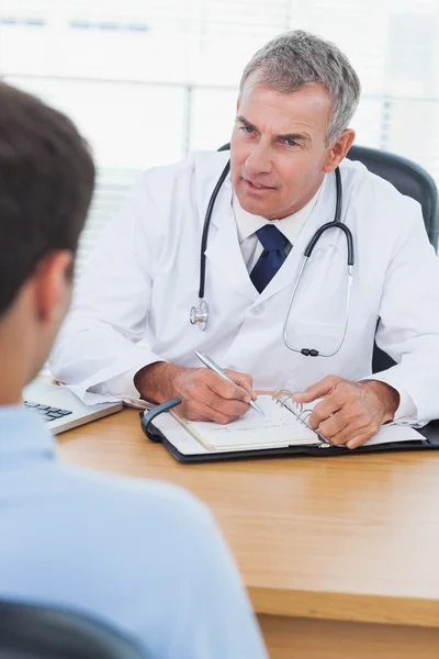 Serious doctor prescribing drug to his patient — Stock Photo, Image