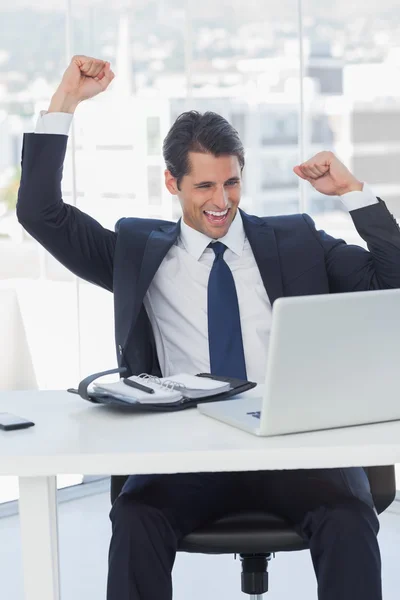 Zakenman juichen en kijken naar zijn laptop — Stockfoto