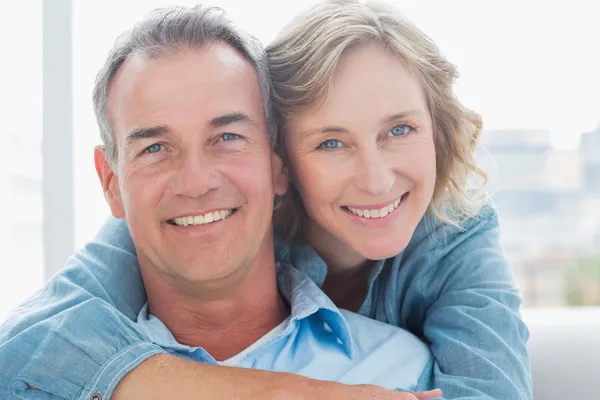 Lachende vrouw haar echtgenoot knuffelen op de Bank van achteren — Stockfoto