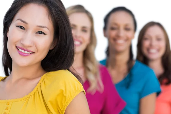 Smiling models in a line posing with focus on asian model — Stock Photo, Image