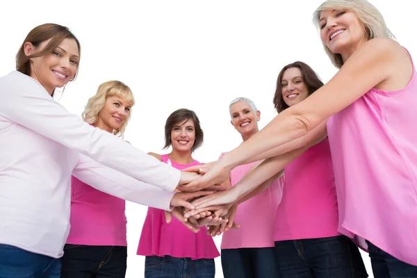 Mujeres posando en círculo cogidas de la mano mirando a la cámara usando p — Foto de Stock