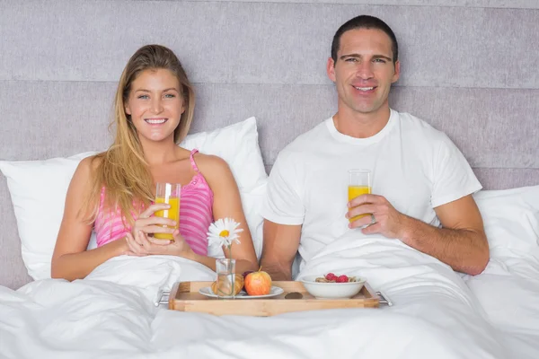 Happy young couple having breakfast in bed — Stock Photo, Image