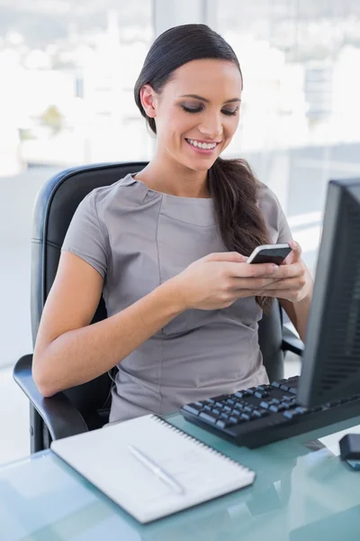 Sonriendo hermosa mujer de negocios mensajes de texto en su teléfono inteligente — Foto de Stock