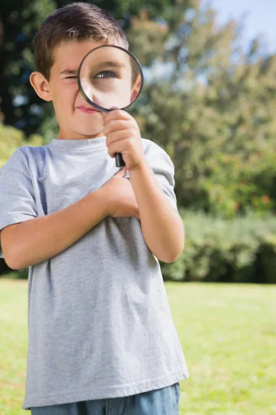 Small child looking through a magnifying glass — Stock Photo, Image