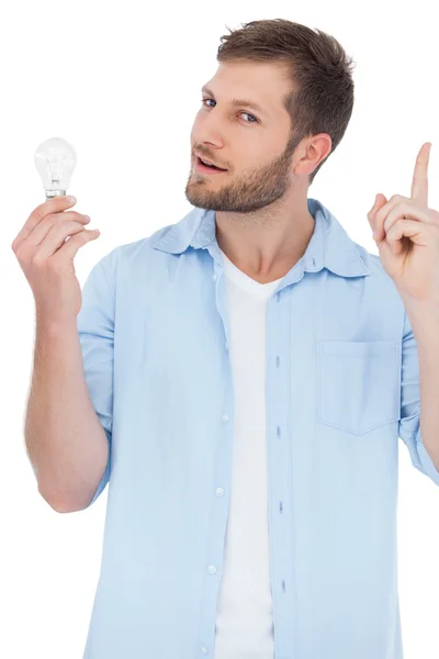 Sceptisch model een lamp te houden en het krijgen van idee — Stockfoto