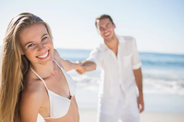 Pretty woman smiling at camera with boyfriend holding her hand — Stock Photo, Image