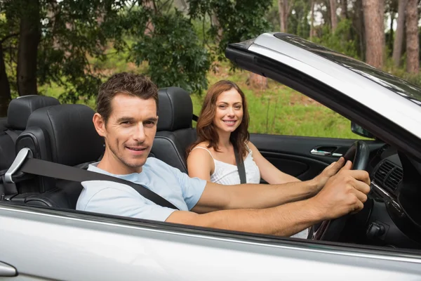 Pareja feliz conduciendo en un convertible plateado — Foto de Stock