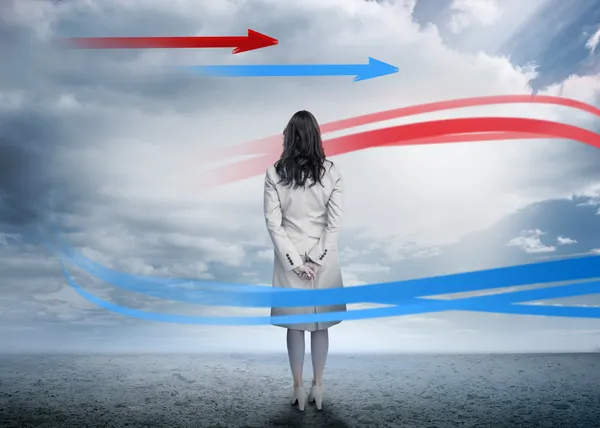 Businesswoman looking at red and blue arrows — Stock Photo, Image