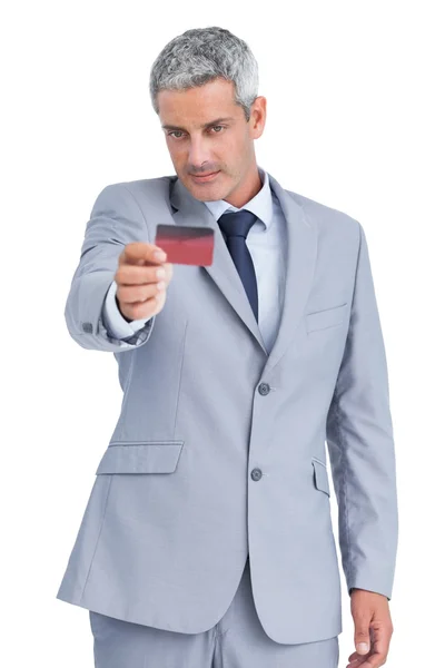 Handsome businessman holding and looking at credit card — Stock Photo, Image