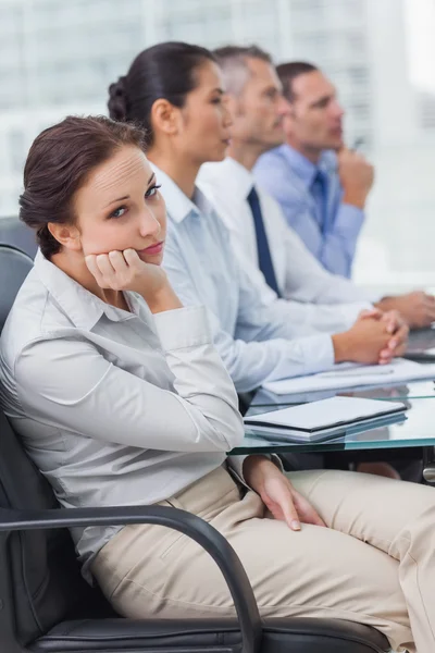 Aburrido mujer de negocios mirando a la cámara mientras asisten presentati — Foto de Stock