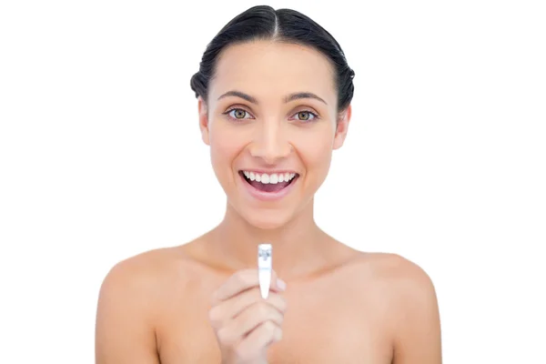 Enthusiastic young brunette holding nail clippers — Stock Photo, Image