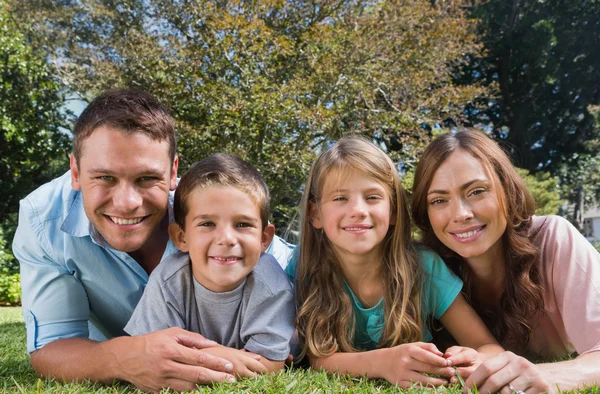 Happy family lying on the grass — Stock Photo, Image