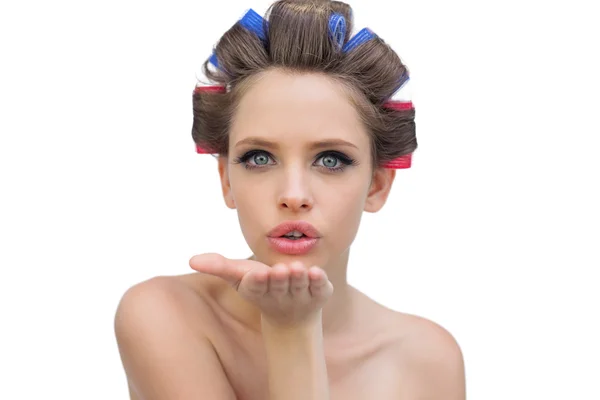 Young model in hair rollers blowing a kiss — Stock Photo, Image