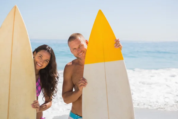 Bonito jovem casal segurando suas pranchas de surf — Fotografia de Stock