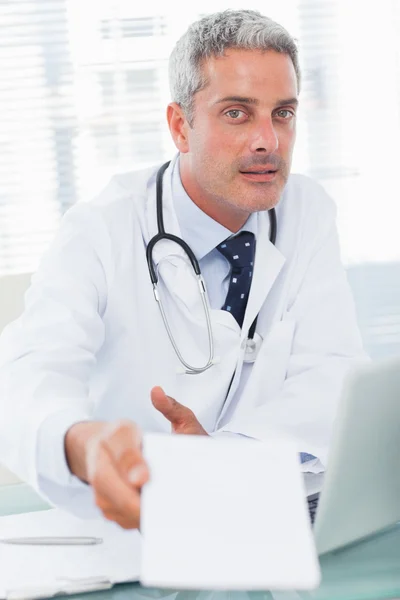 Doctor giving prescription to camera — Stock Photo, Image