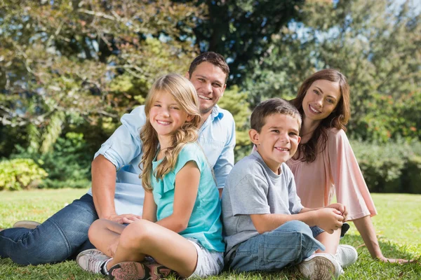 Junge Familie sitzt in einem Park — Stockfoto