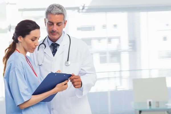 Nurse and doctor looking a file — Stock Photo, Image