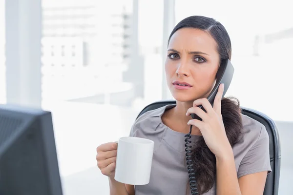 Worried secretary answering phone — Stock Photo, Image