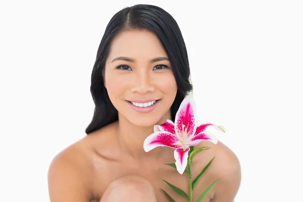 Lächelnd natürliches schwarzhaariges Model posiert mit Lilie — Stockfoto