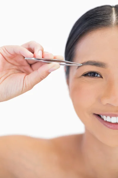 Half face of smiling natural woman using tweezers — Stock Photo, Image