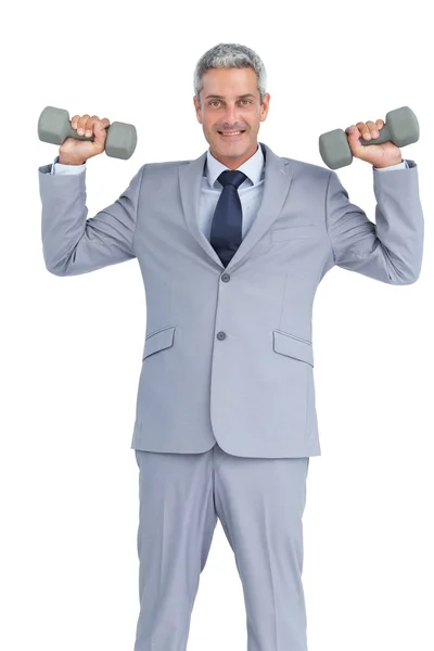 Businessman lifting dumbbells — Stock Photo, Image