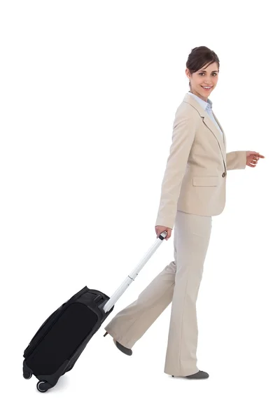 Cheerful businesswoman pulling suitcase — Stock Photo, Image