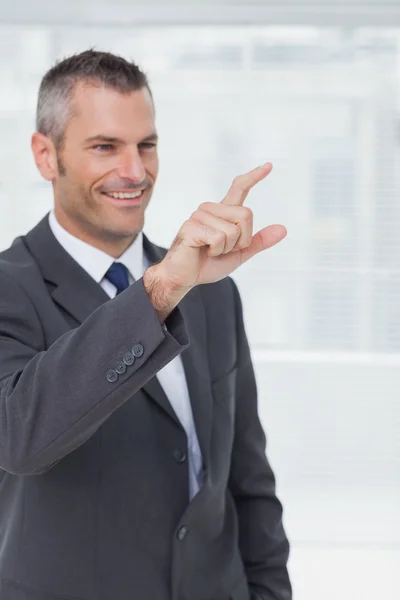 Cheerful businessman pointing and looking straight ahead — Stock Photo, Image